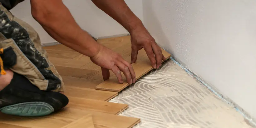 Worker placing wooden pieces on the floor